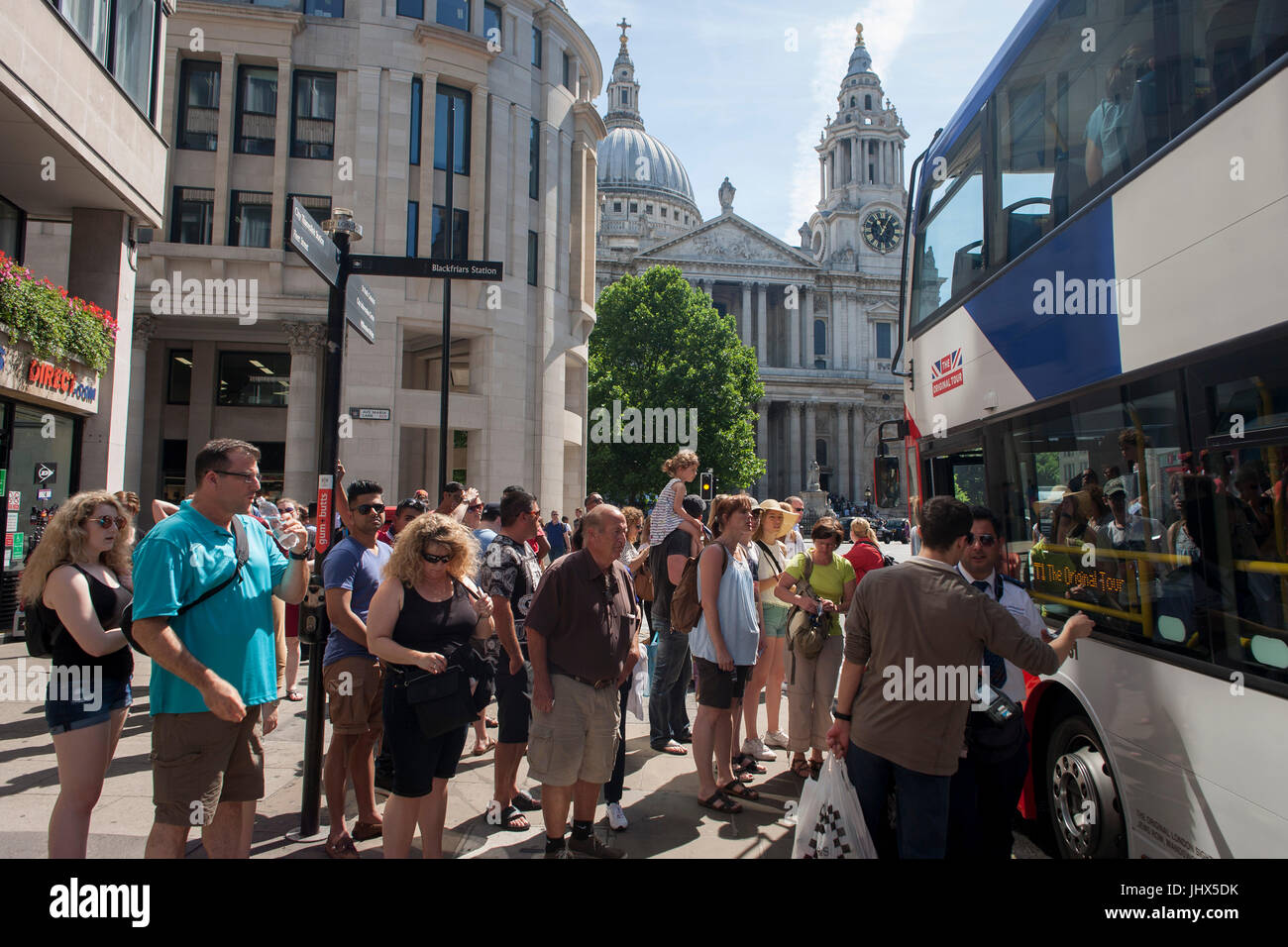 A tour bus with The Original Tour latest branding of a Union jack flag picks up passengers with St. Paul's Cathedral beyond, on Ludgate Hill, on 7th July 2017, in central London. Stock Photo