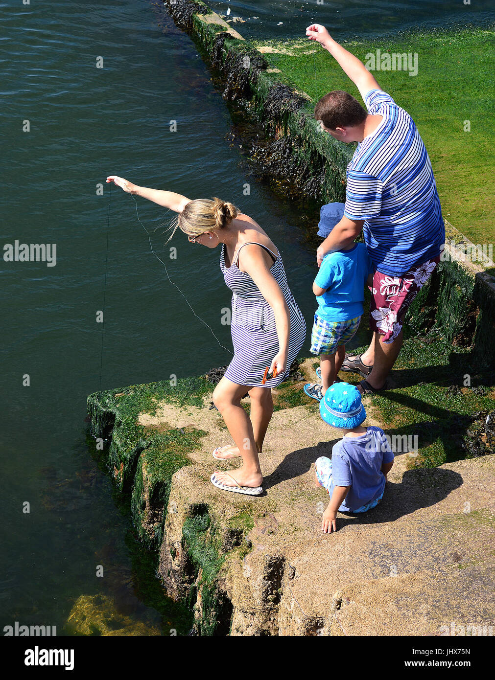 Mum, Dad and two kids crab fishing off Berry Head, Torbay, Devon Stock Photo