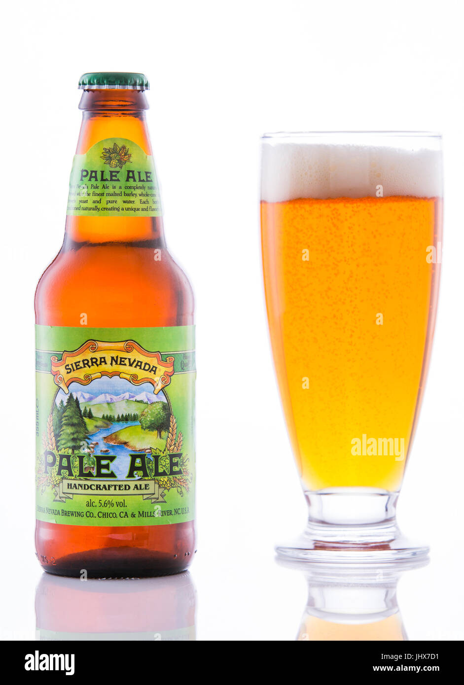 Sierra Nevada Pale Ale bottle and glass on a white reflective surface against a white background. Stock Photo