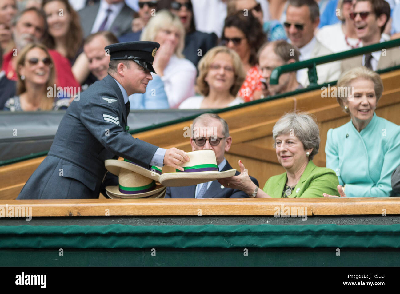 Wimbledon, London, UK. 16th July, 2017. The Wimbledon Tennis Championships 2017 held at The All England Lawn Tennis and Croquet Club, London, England, UK. GENTLEMEN'S SINGLES - FINAL Roger Federer (SUI) [3] v Marin Cilic (CRO) [7] on Centre Court. Prime Minister Theresa May watches the match from the Royal Box with her husband Philip. She assists a steward to distribute panama hats to other guests in the Royal Box. Credit: Duncan Grove/Alamy Live News Stock Photo