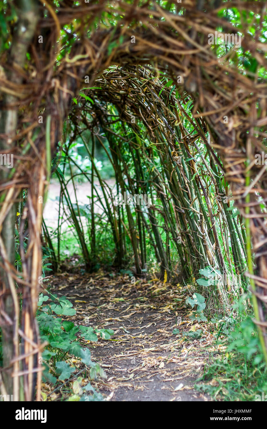 Narrow path in a tree tunnel , play area for children near a playground Stock Photo