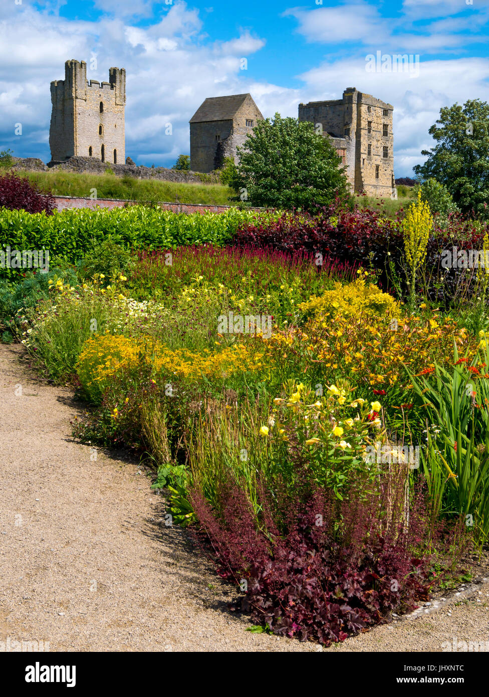 Helmsley Castle overlooking the Helmsley Walled Garden with a show of summer flowers Stock Photo