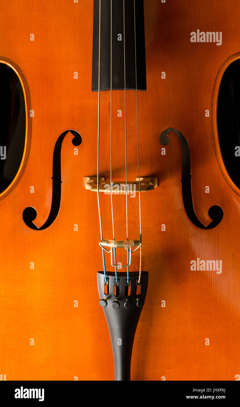 Close up of musical stringed instrument, cello f hole, bridge, tailpiece and fine tuners Stock Photo