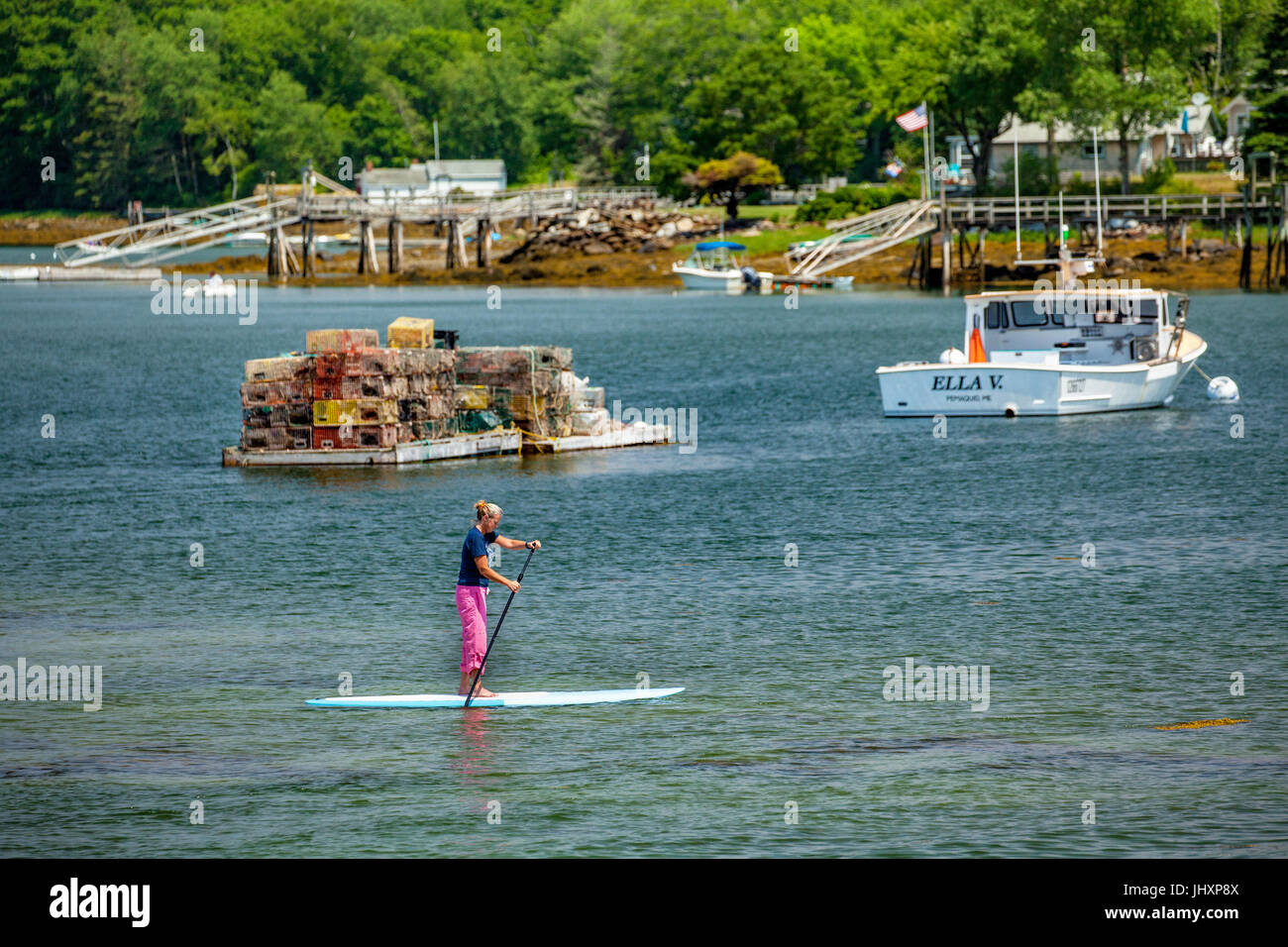 a woman paddleboards on Pemaquid Bay in Bristol, Maine, USA. Stock Photo