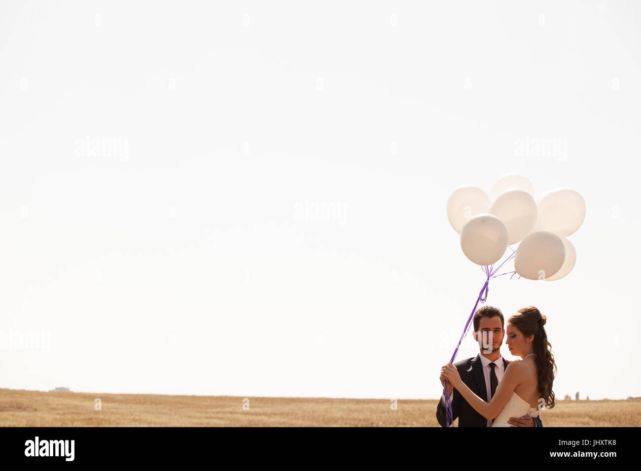 Married happy couple holding ballons in hand Stock Photo - Alamy