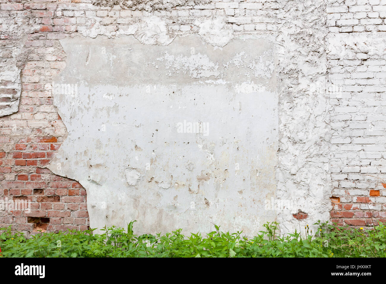 Aged brick wall with cracked plaster Stock Photo