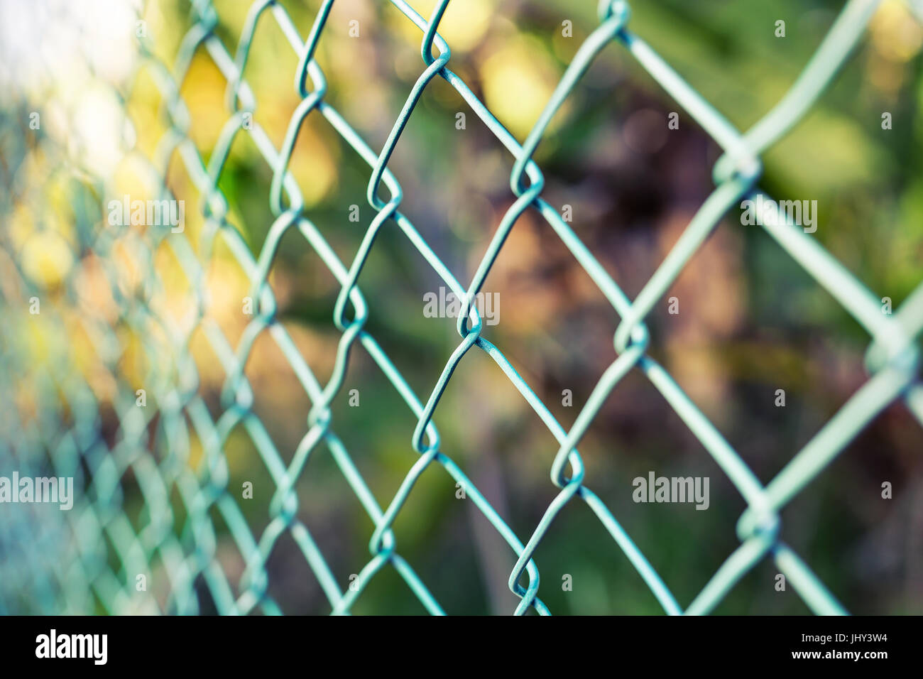 Wire fence with green grass on background Stock Photo - Alamy