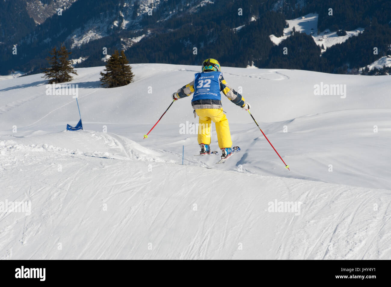 Little skiing kid flying over a jump on a race track in the ski area of Disentis 3000, Switzerland Stock Photo