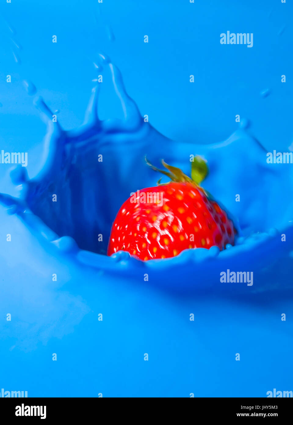 Strawberry falls in blue liquid, Erdbeere fällt in blaue Flüssigkeit Stock Photo