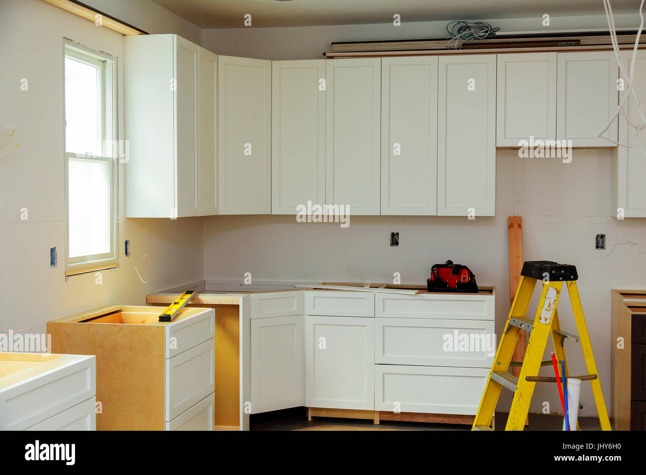 Custom kitchen cabinets in various stages of installation Stock Photo