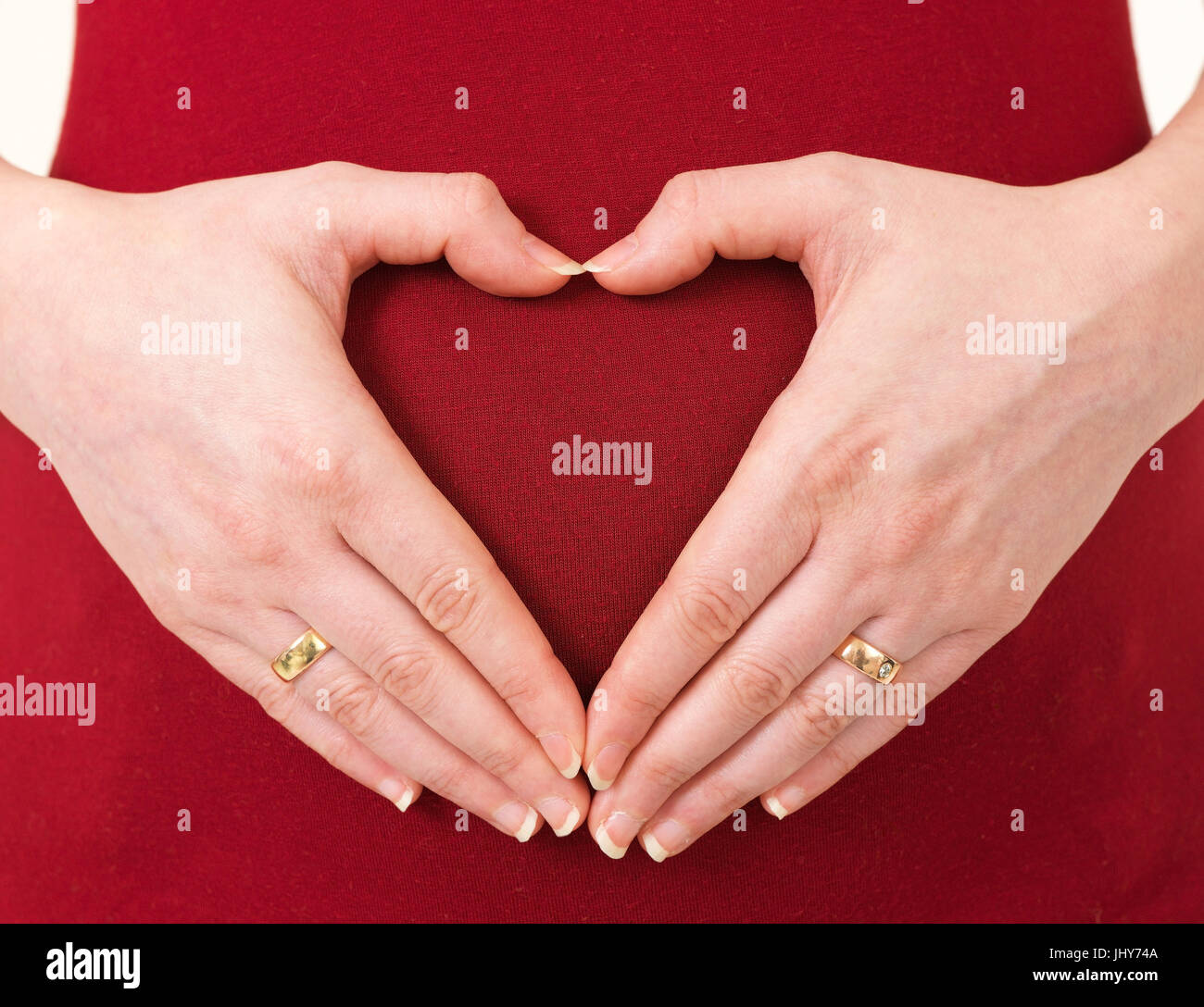 Hand in heart form on baby belly - heart on baby belly, Hand in Herzform auf Babybauch - heart on baby belly Stock Photo