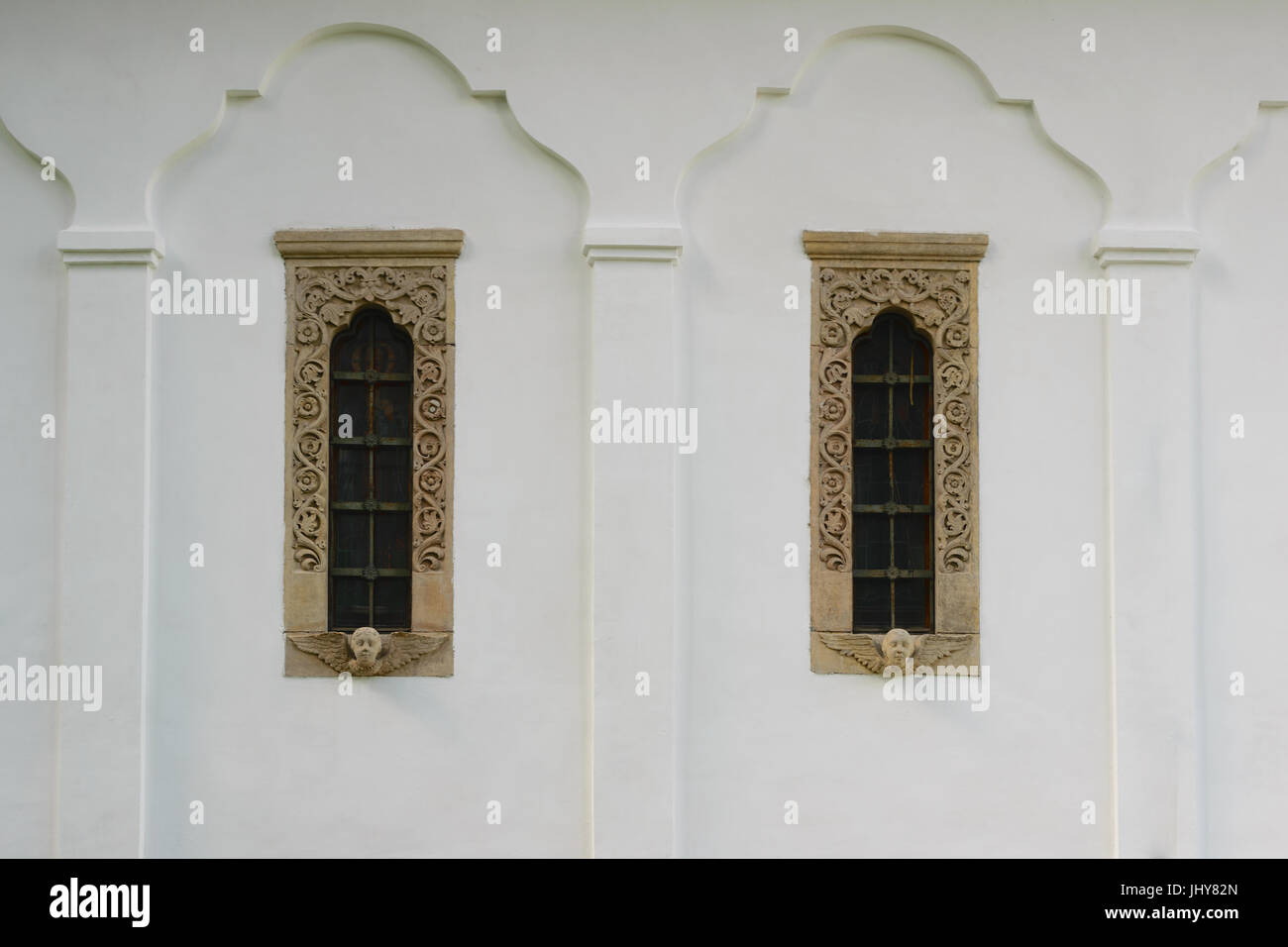 18th century style windows frame and decoration sculptured in stone on white walls background - exterior Stock Photo