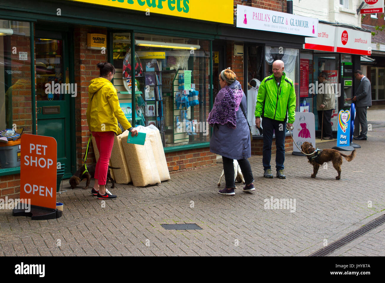 A small group of animal lovers with their dogs meet and chat outside the local pet shop in Hythe in Hampshire on the south coast of England Stock Photo
