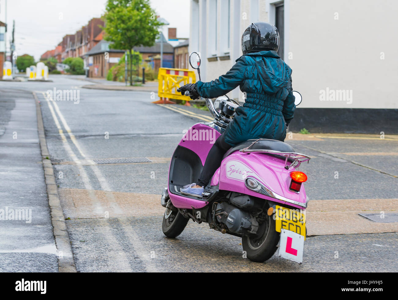 Woman with L learner plates riding a Pink Sinnis ZNEN ZN 125 T-E5 Spirit retro motor scooter from 2014. Stock Photo
