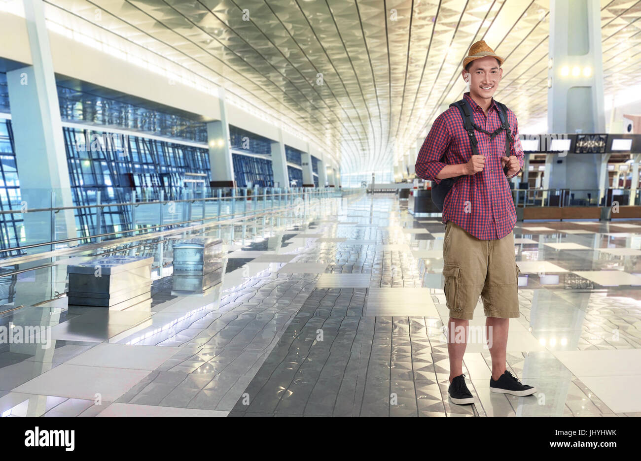 Traveler asian man wearing hat with backpack in the airport terminal Stock Photo