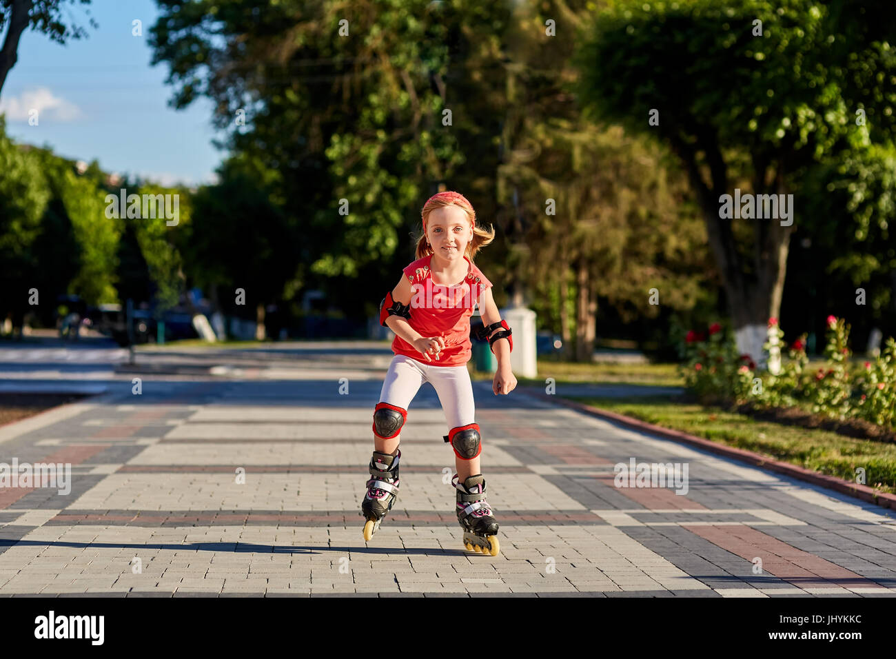 Girl riding on roller skates in skatepark summer outdoor. Child in a