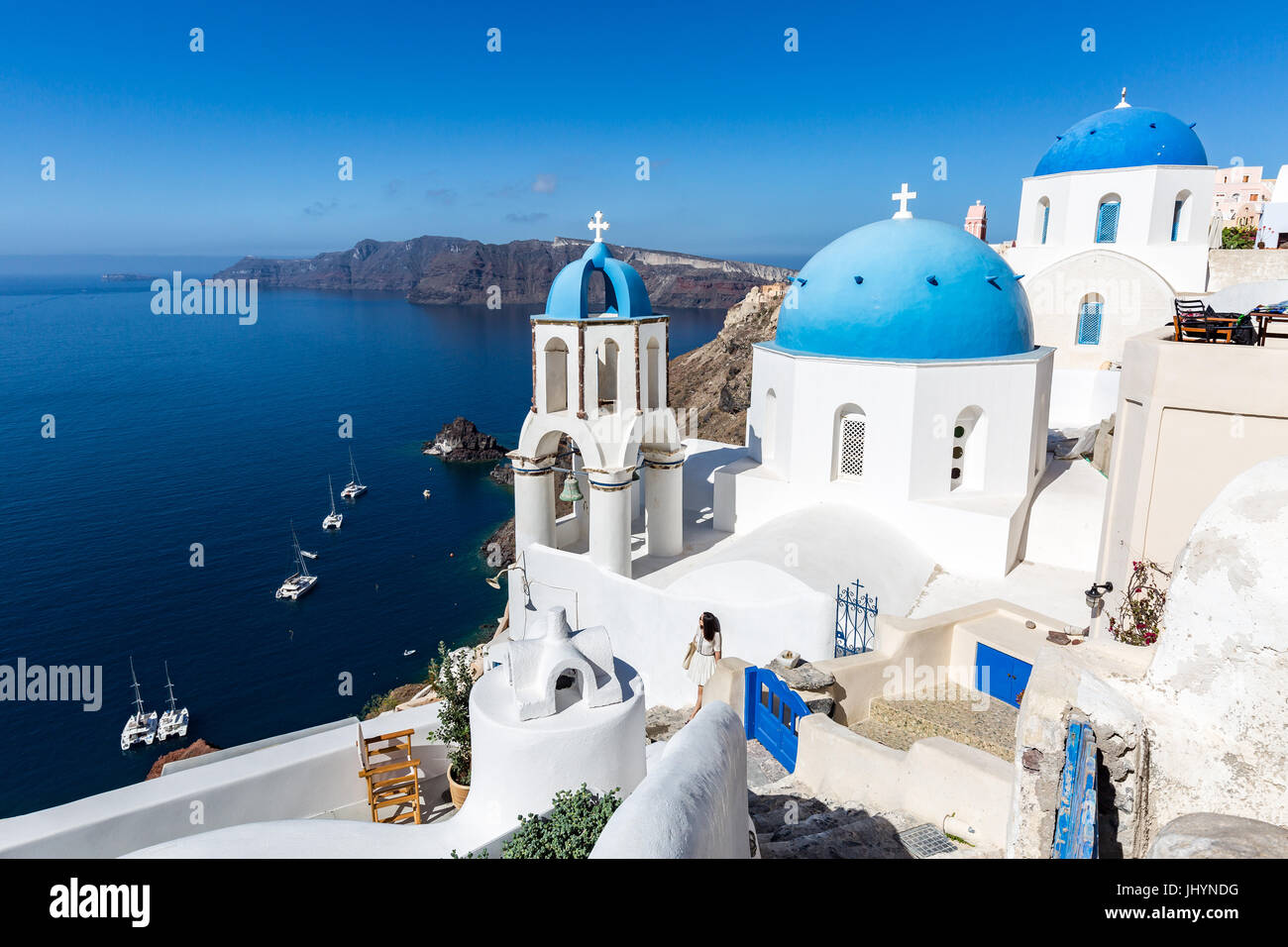 White washed stone buildings and the blue cupolas of a church in Oia, Santorini, Cyclades, Greek Islands, Greece, Europe Stock Photo