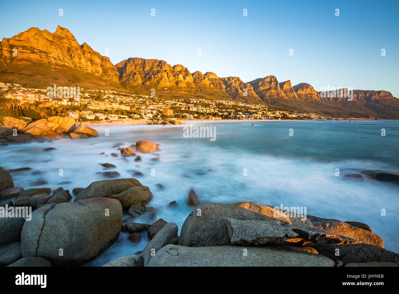 Sunset in Camps Bay with Table Mountain on the left and the Twelve Apostles to the right, Western Cape, South Africa Stock Photo