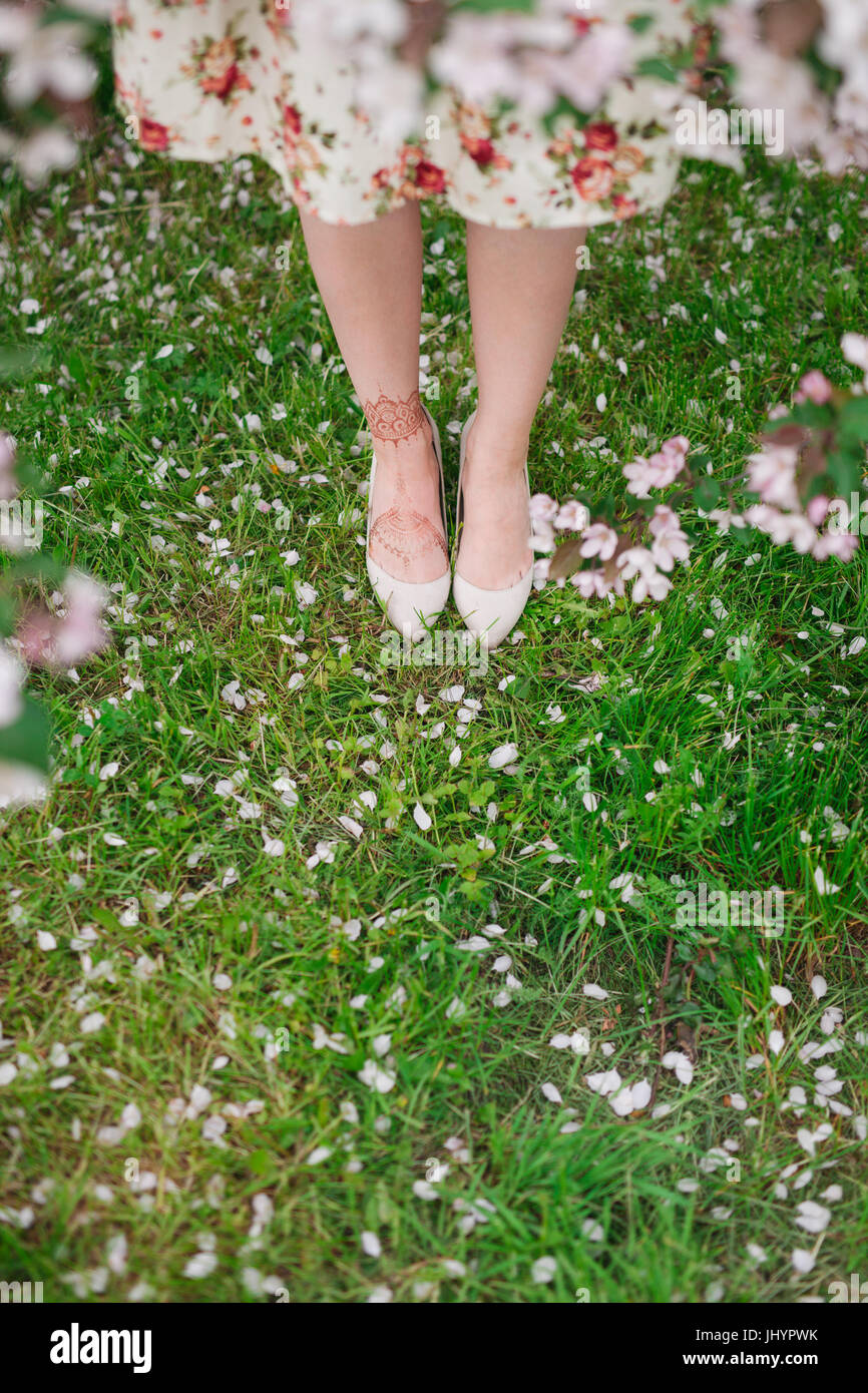 Girl in flower dress walking in the field of grass, body detail Stock Photo