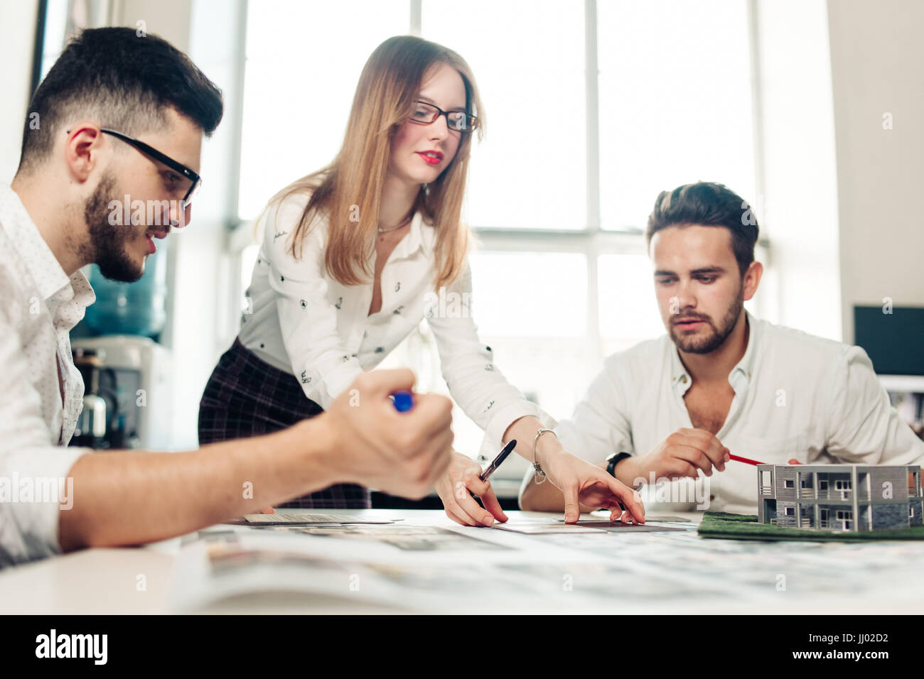 Confident team of engineers working together in a architect studio Stock Photo