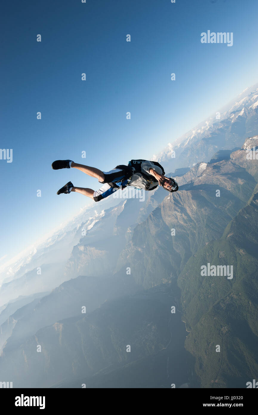 A skydiver tracking above Locarno, Switzerland with the Alps in the background Stock Photo