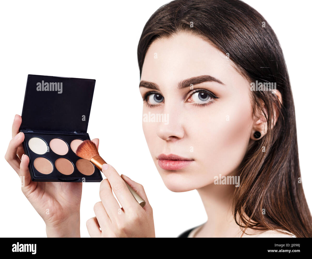Young woman holding palette for contouring face. Stock Photo
