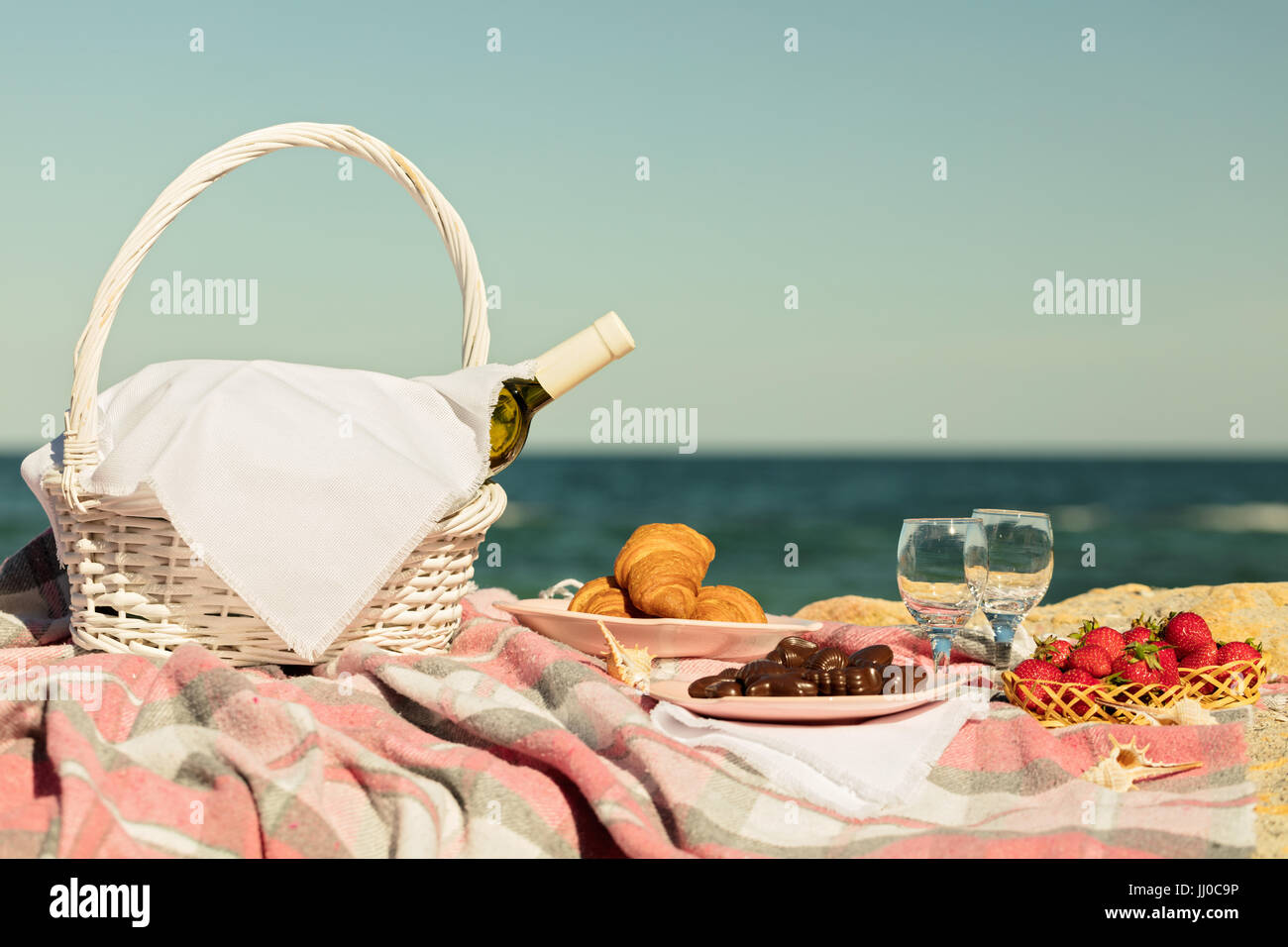 Summer time at the sea. Romantic picnic on the beach wine