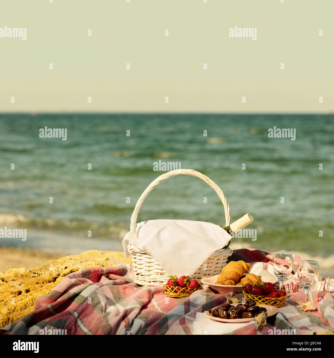 Summer time at the sea. Romantic picnic on the beach wine