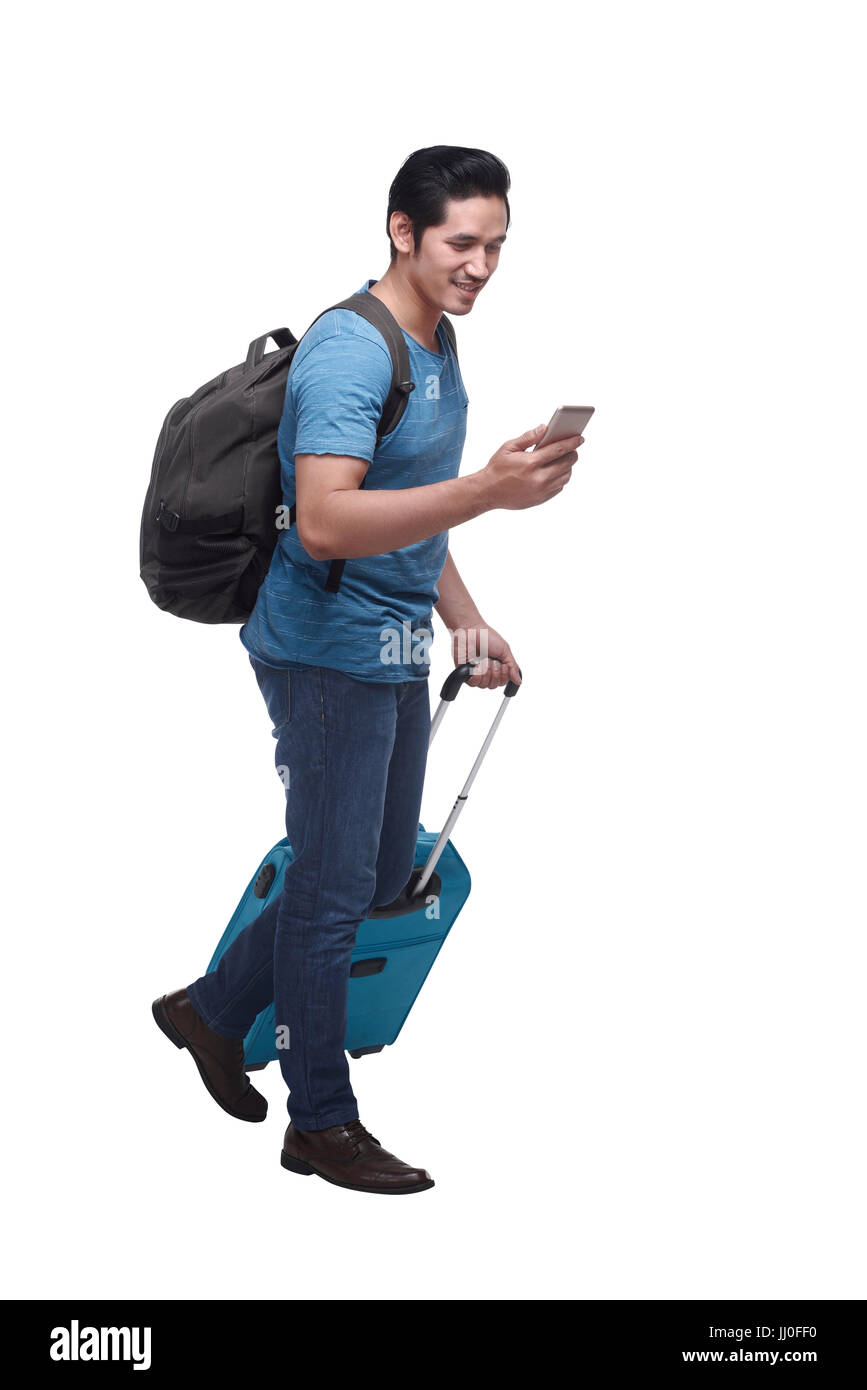Handsome asian tourist on mobile phone with suitcase isolated over white background Stock Photo