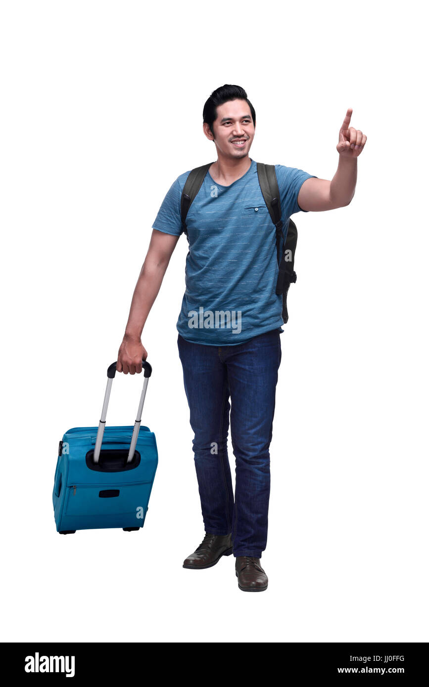 Happy asian traveler with backpack and suitcase pointing something isolated over white background Stock Photo