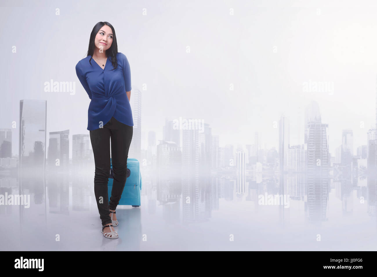 Happy asian woman traveling with suitcase against futuristic background Stock Photo
