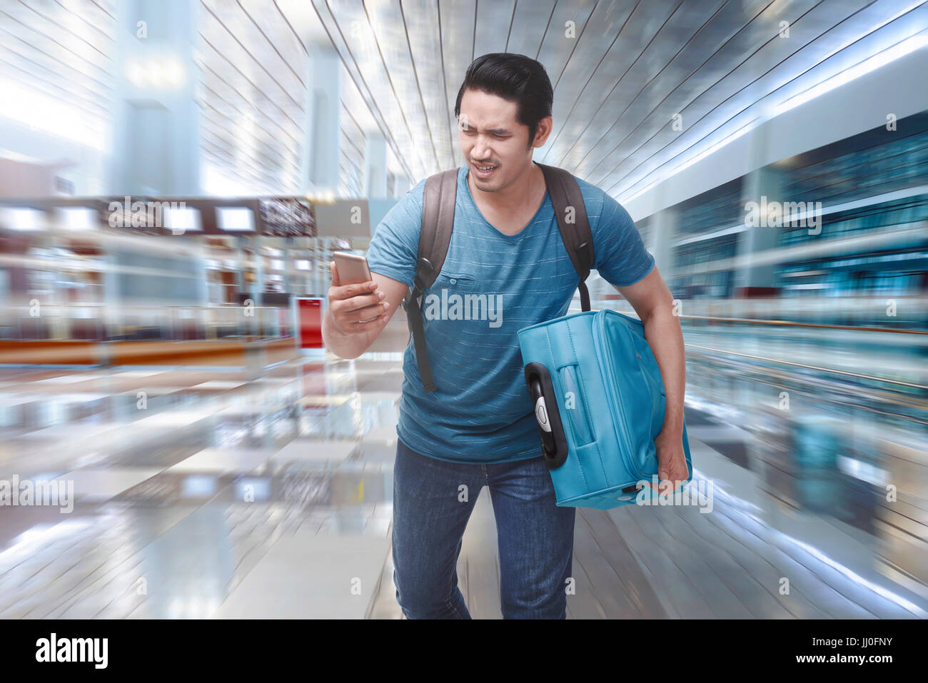 Young asian tourist rushing to boarding a plane on the departure area Stock Photo