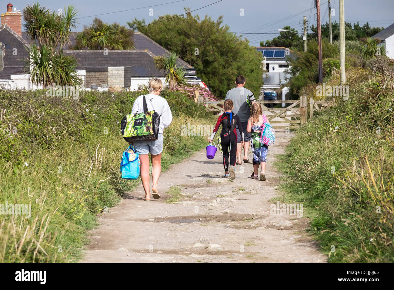 A family of holidaymakers walking back home after a day out. Stock Photo