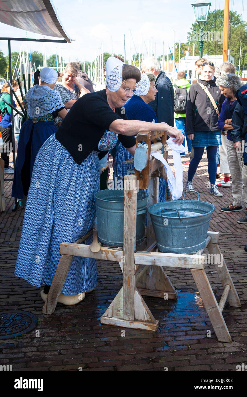 Netherlands, Zeeland, the village Veere on the peninsula Walcheren, historic market at the market place, woman washes clothes with an old washing mach Stock Photo