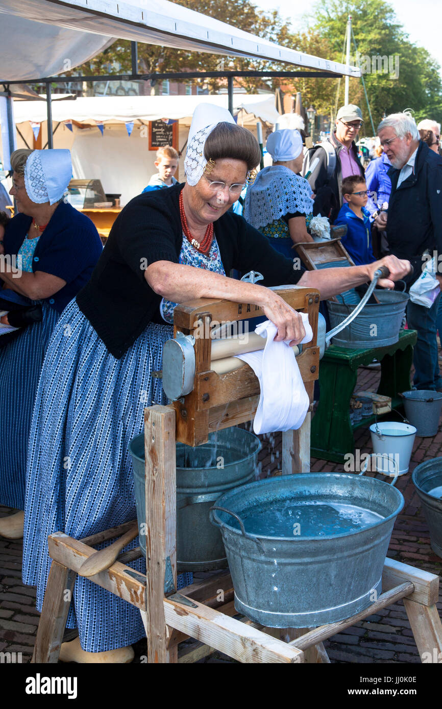 Netherlands, Zeeland, the village Veere on the peninsula Walcheren, historic market at the market place, woman washes clothes with an old washing mach Stock Photo