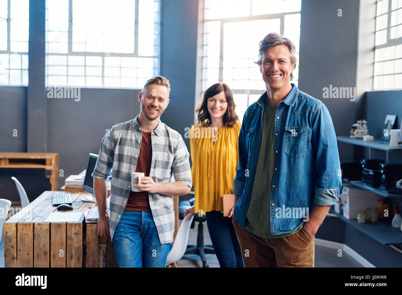 Smiling young coworkers standing together in a modern office Stock Photo