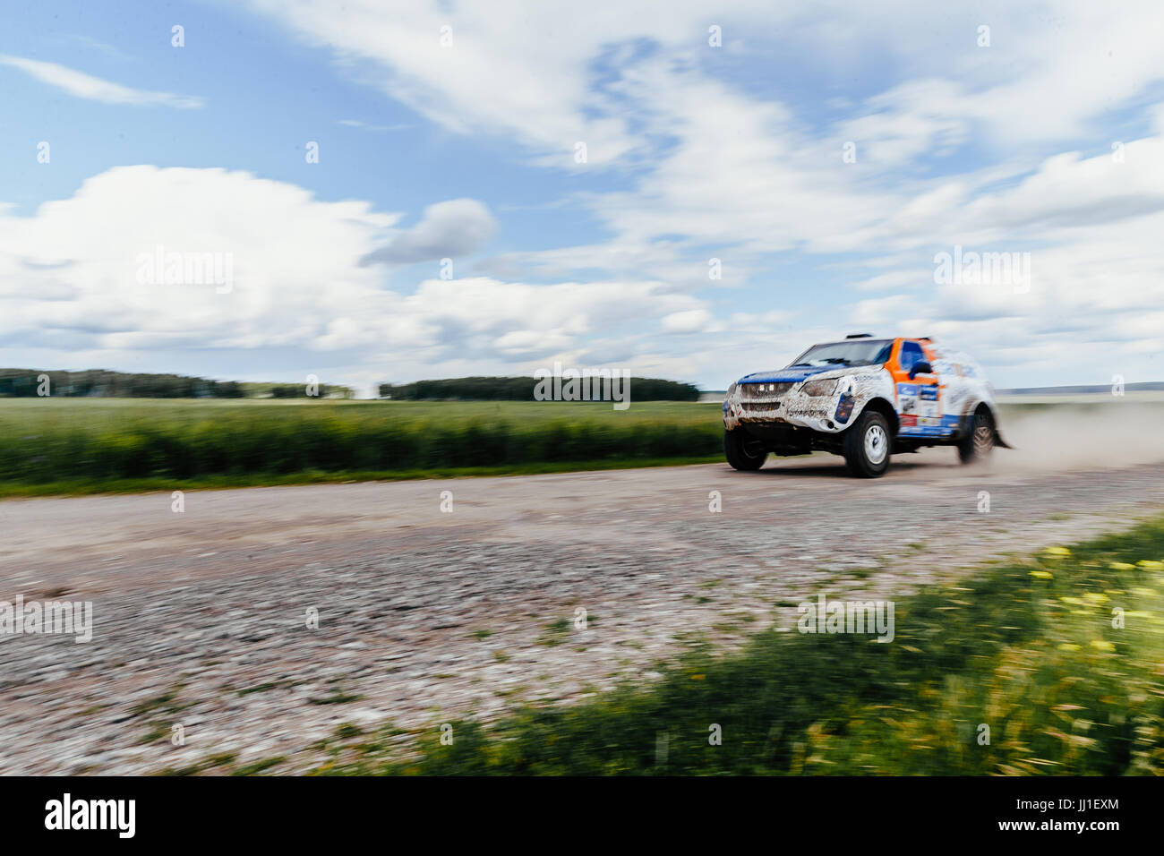 blurred motion rally car driving on gravel road Stock Photo