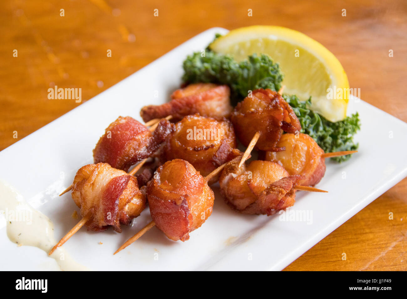 Locally sourced scallops wrapped in bacon at The Nantucket Lobster Trap Restaurant, Nantucket, MA, USA Stock Photo