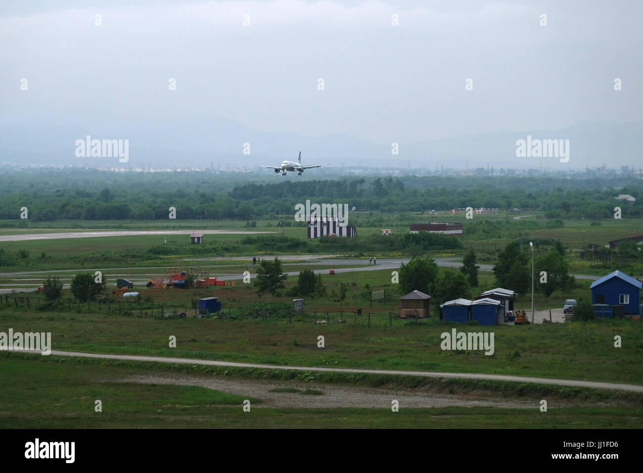 An airplane landing in Yuzhno-Sakhalinsk Airport also called Khomutovo in the city of Yuzhno-Sakhalinsk, in the island of Sakhalin, in the Pacific Ocean. Russia Stock Photo