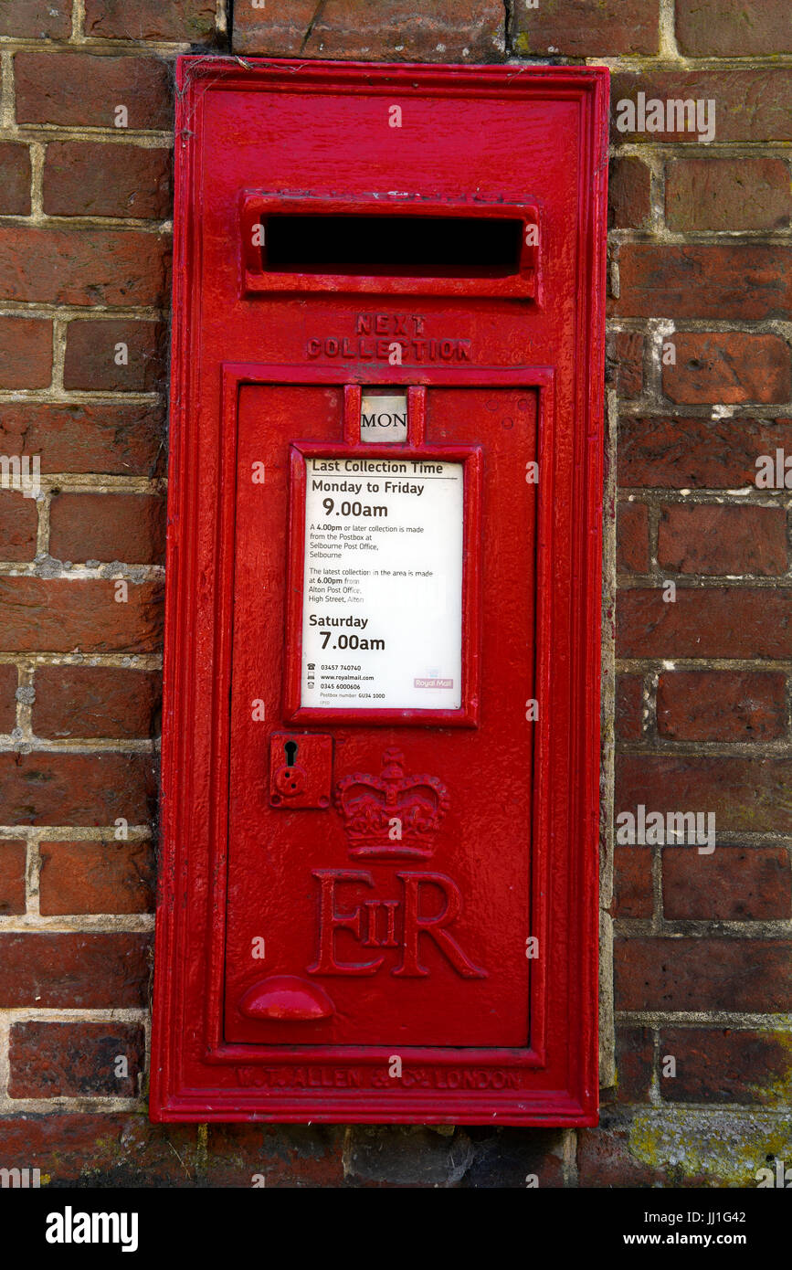 Traditional Royal Mail red post box on the wall in the village of Selborne, Hampshire, UK. Stock Photo