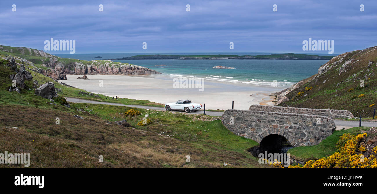 Car driving on desolate road past Ceannabeinne Beach in summer near Durness, Sutherland, Scottish Highlands, Scotland Stock Photo