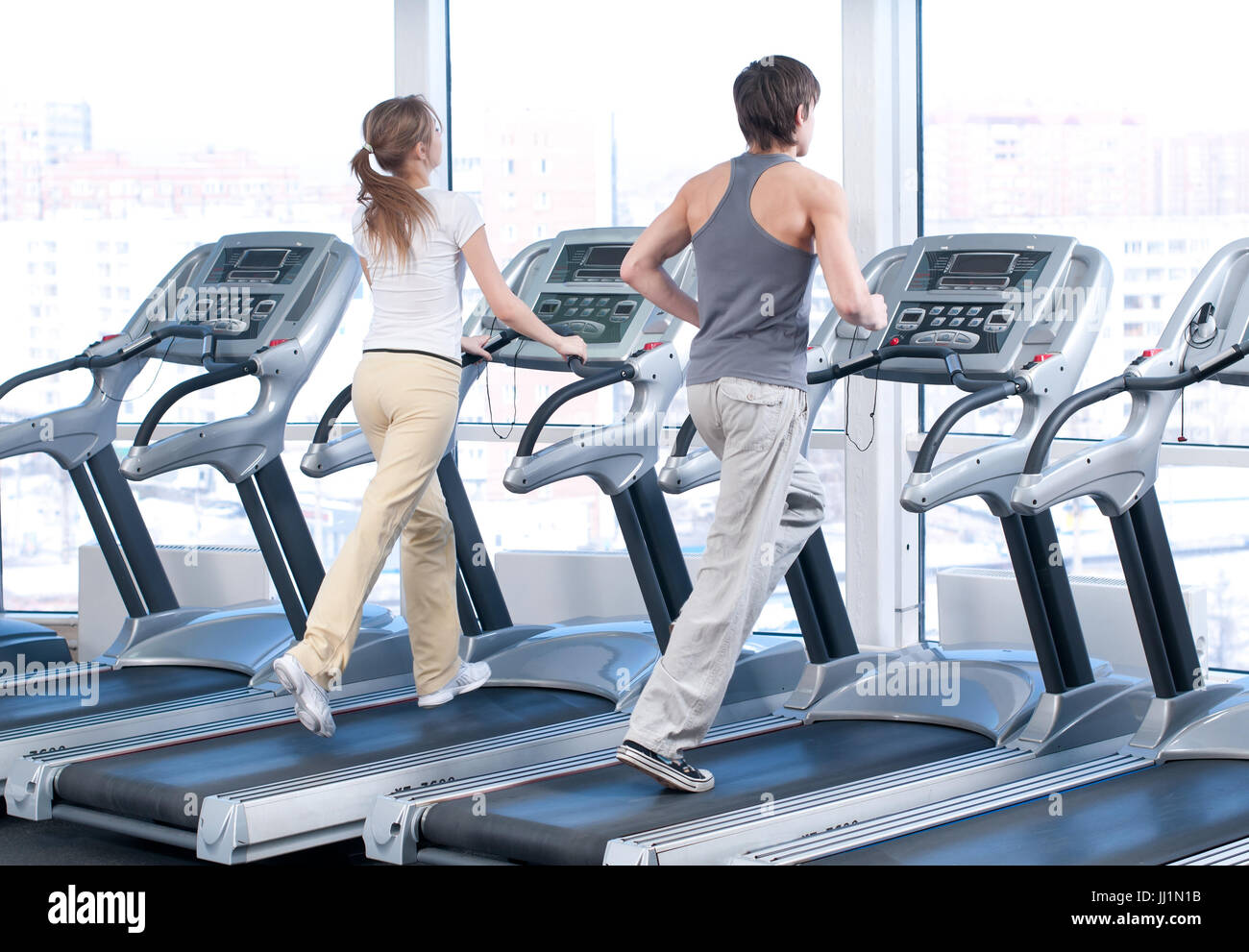 Young woman and man at the gym exercising. Running Stock Photo - Alamy