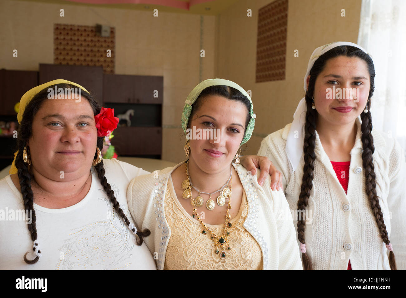 Three women of a wealthy Roma gypsy family posing inside their luxury house, Ivanesti, Romania Stock Photo