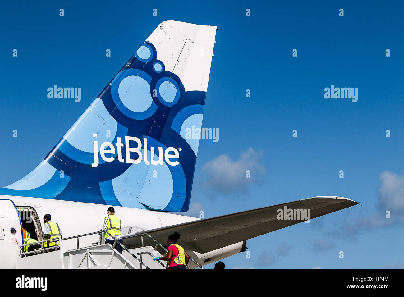 Members of service crew are entering a JetBlue airplane following its landing at Maurice Bishop airport. Stock Photo
