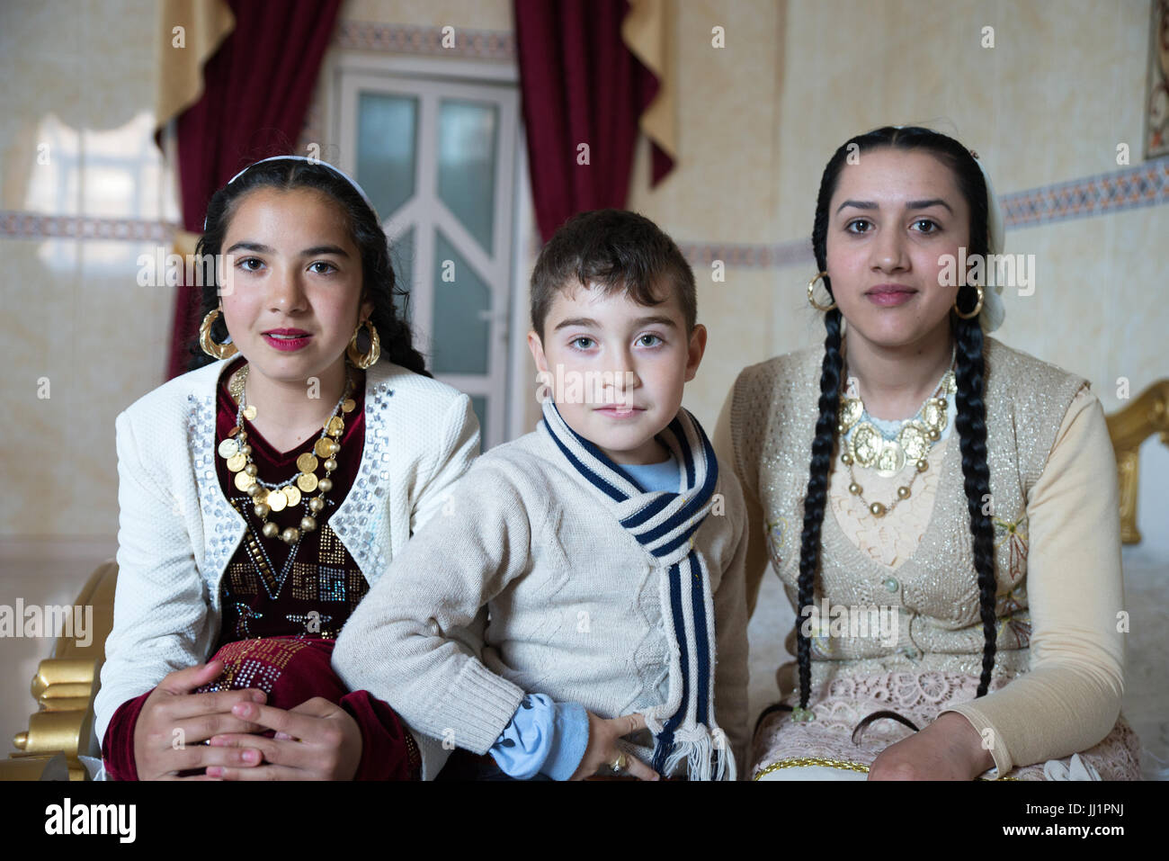 Kids of a wealthy Roma gypsy family posing in the luxurious bedroom of their house, Ivanesti, Romania Stock Photo