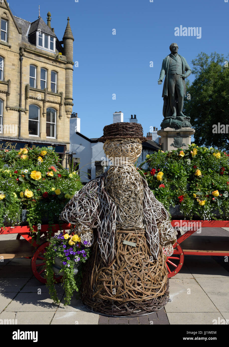 Bury in bloom display, wicker flower seller with flower covered hand