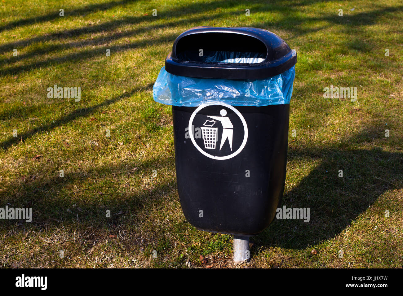 Plastic garbage bin on grass. Sorted waste. Throw out. Park trash bin