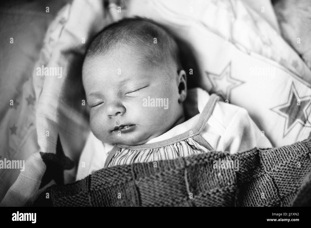 Close up of beautiful newborn baby daughter lying on bed Stock Photo