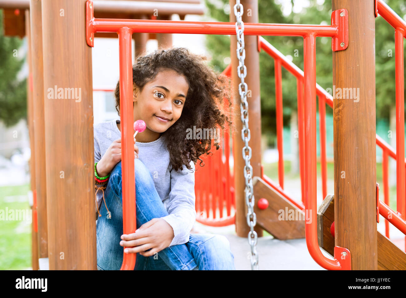 African american girl on playground eating lollipop. Stock Photo