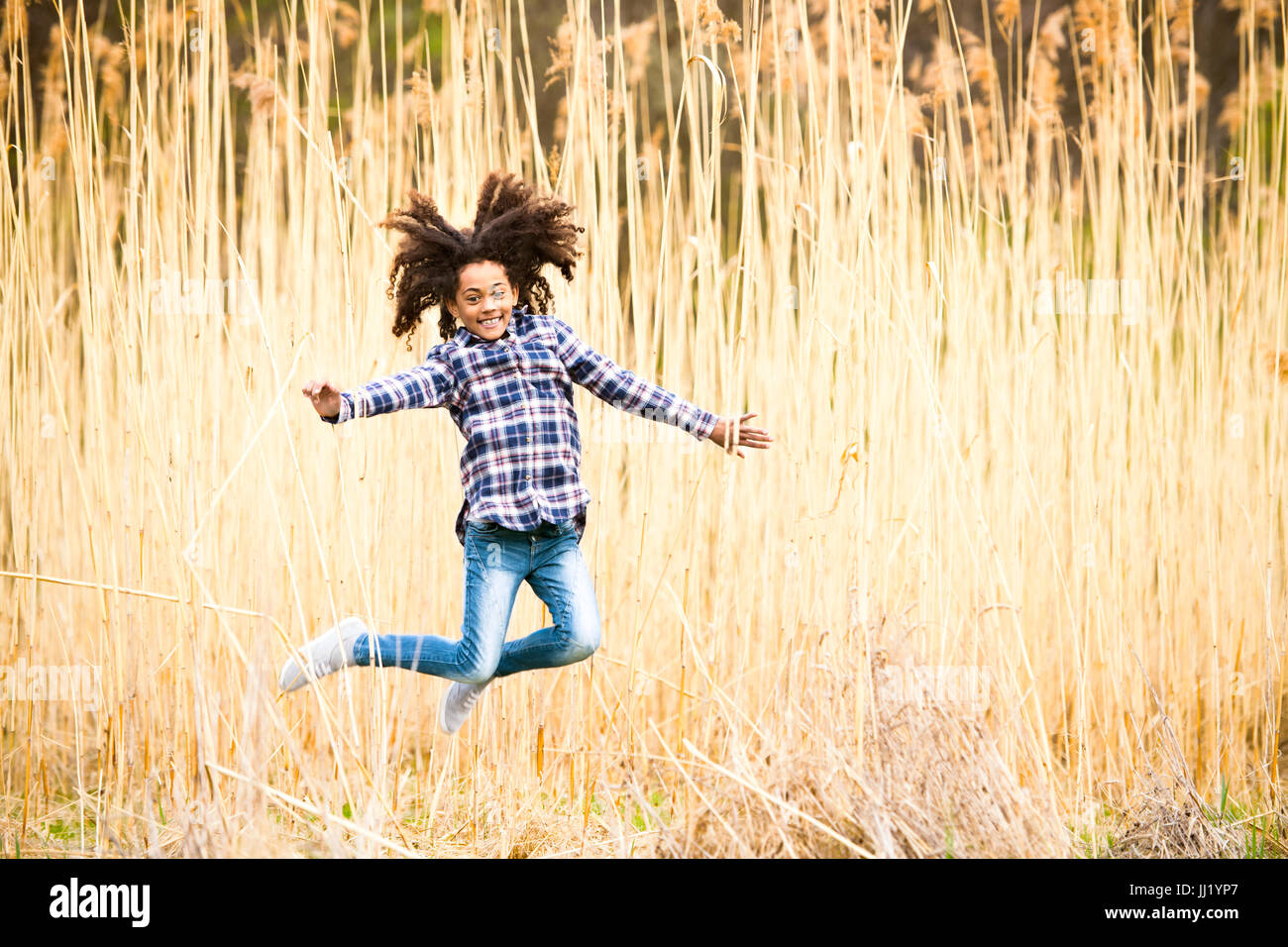 African american girl in checked shirt outdoors in field. Stock Photo